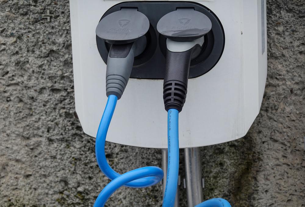 Borne de recharge murale avec deux câbles bleus branchés, vue rapprochée